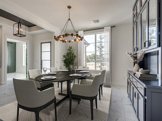 1117 Falls Bridge Ct, Edmond, OK 73034 - dining space with light marble finish flooring, a chandelier, and baseboards