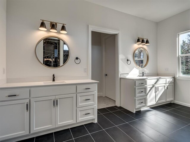 1117 Falls Bridge Ct, Edmond, OK 73034 - bathroom with two vanities, tile patterned flooring, and baseboards