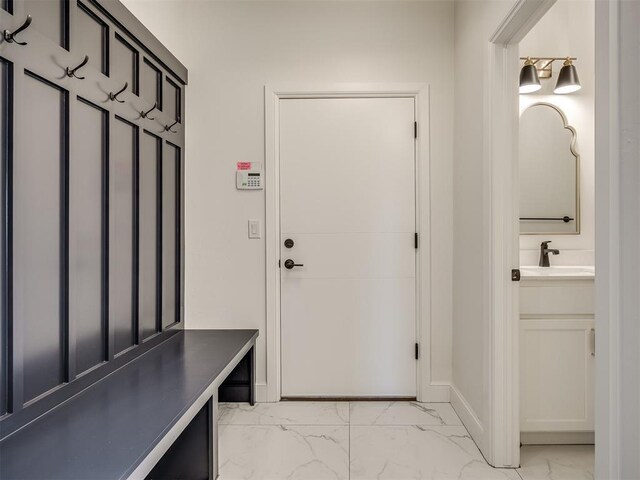 1117 Falls Bridge Ct, Edmond, OK 73034 - mudroom featuring light marble finish floors, a sink, and baseboards