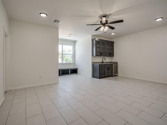 1117 Falls Bridge Ct, Edmond, OK 73034 - unfurnished living room featuring wine cooler, a ceiling fan, baseboards, recessed lighting, and bar with sink