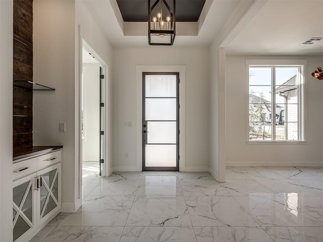 1117 Falls Bridge Ct, Edmond, OK 73034 - entrance foyer featuring baseboards, light marble finish flooring, and a chandelier