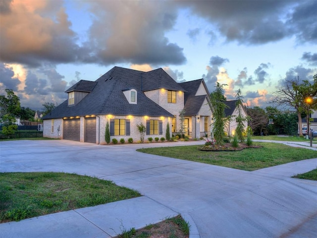 1117 Falls Bridge Ct, Edmond, OK 73034 - french country inspired facade featuring driveway, a yard, brick siding, and a shingled roof