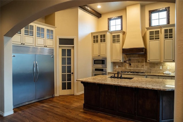 3176 E 146th Pl, Bixby, OK 74008 - kitchen with built in appliances, arched walkways, a sink, decorative backsplash, and light stone counters