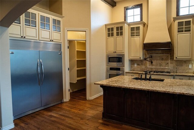 3176 E 146th Pl, Bixby, OK 74008 - kitchen featuring built in appliances, custom exhaust hood, a sink, backsplash, and light stone counters