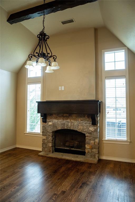 3176 E 146th Pl, Bixby, OK 74008 - unfurnished living room with baseboards, dark wood-style floors, healthy amount of natural light, and a stone fireplace