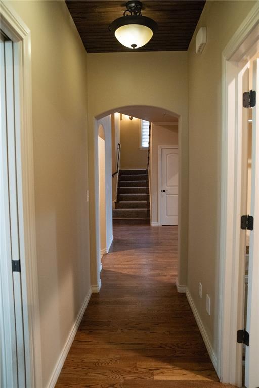 3176 E 146th Pl, Bixby, OK 74008 - corridor featuring arched walkways, dark wood-type flooring, baseboards, and wooden ceiling
