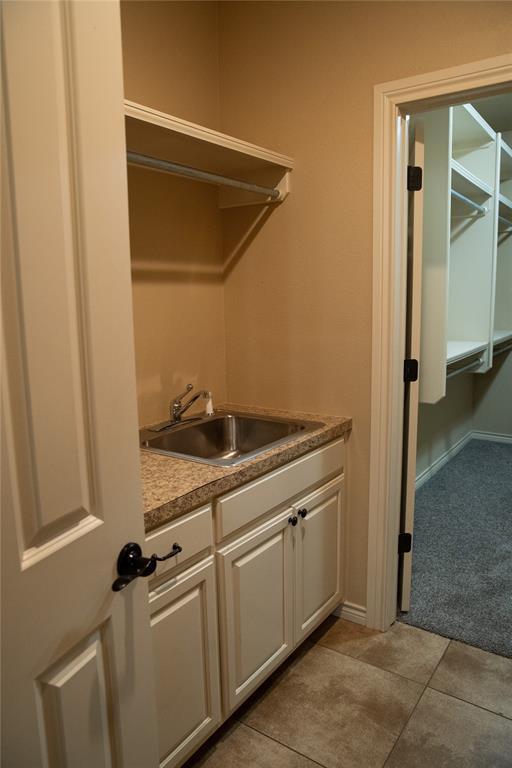 3176 E 146th Pl, Bixby, OK 74008 - washroom with a sink, light tile patterned floors, light carpet, and baseboards