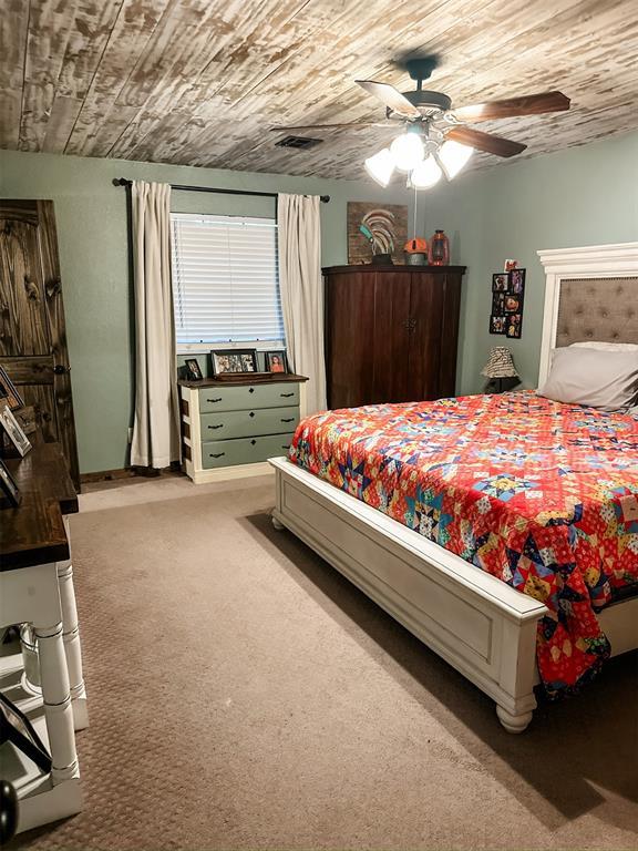 1913 Linwood St, Weatherford, OK 73096 - bedroom featuring carpet floors, wood ceiling, and ceiling fan