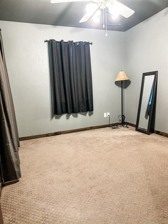 1913 Linwood St, Weatherford, OK 73096 - unfurnished room featuring light carpet, ceiling fan, and baseboards