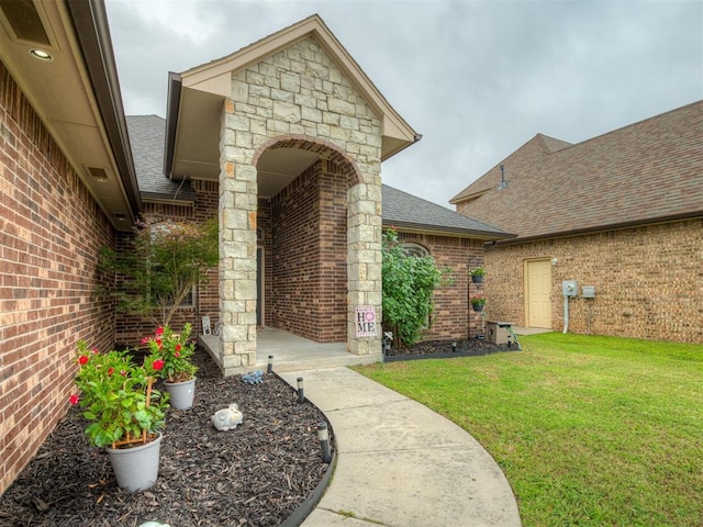 14512 Briarcliff St, Oklahoma City, OK 73170 - doorway to property with roof with shingles, brick siding, and a yard