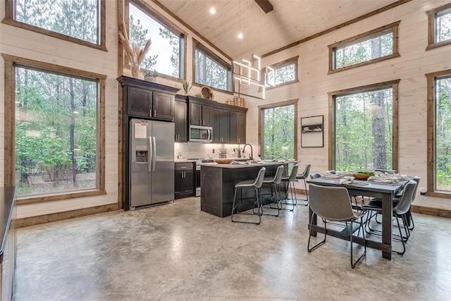 166 Morning Berry Trl, Broken Bow, OK 74728 - dining space featuring high vaulted ceiling, healthy amount of natural light, wood walls, wooden ceiling, and concrete flooring