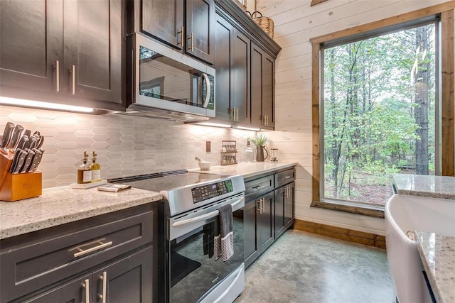 166 Morning Berry Trl, Broken Bow, OK 74728 - kitchen featuring stainless steel appliances, tasteful backsplash, wood walls, light stone counters, and dark brown cabinetry