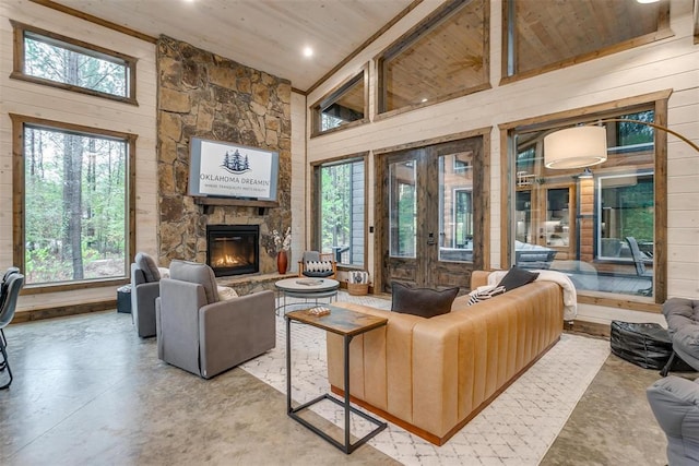 166 Morning Berry Trl, Broken Bow, OK 74728 - living room with wood walls, plenty of natural light, a fireplace, wood ceiling, and high vaulted ceiling
