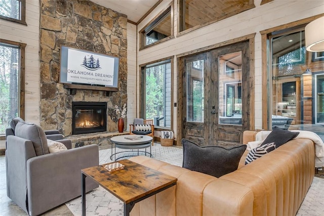 166 Morning Berry Trl, Broken Bow, OK 74728 - living room featuring wood walls, a stone fireplace, and a high ceiling