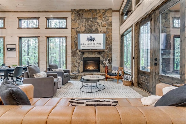 166 Morning Berry Trl, Broken Bow, OK 74728 - living room with wooden walls, healthy amount of natural light, wood finished floors, and a stone fireplace