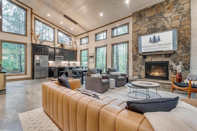166 Morning Berry Trl, Broken Bow, OK 74728 - living area with wooden ceiling, high vaulted ceiling, concrete floors, healthy amount of natural light, and a stone fireplace