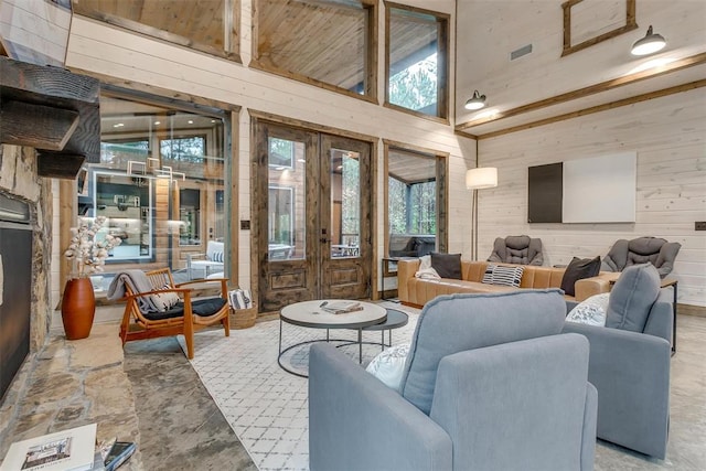 166 Morning Berry Trl, Broken Bow, OK 74728 - living room featuring french doors, wooden walls, a high ceiling, and stone finish flooring