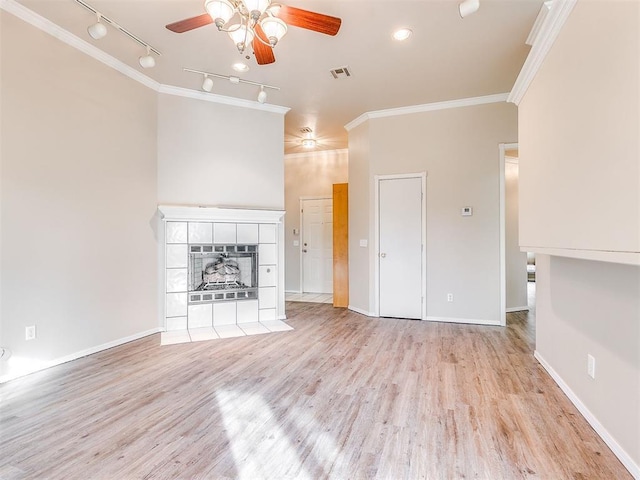 400 W 10th St, Edmond, OK 73003 - unfurnished living room featuring a ceiling fan, rail lighting, crown molding, light wood-style flooring, and baseboards