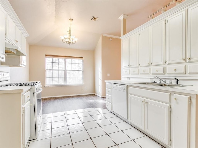 400 W 10th St, Edmond, OK 73003 - kitchen with white appliances, a sink, a chandelier, light countertops, and white cabinetry