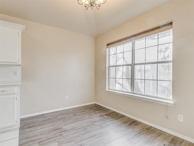 400 W 10th St, Edmond, OK 73003 - empty room with light wood-style floors, a chandelier, and baseboards