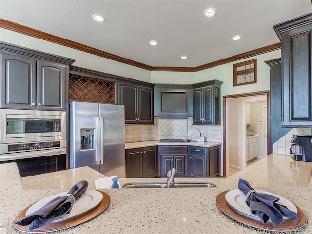 5608 NW 103rd St, Oklahoma City, OK 73162 - kitchen featuring appliances with stainless steel finishes, light stone counters, a sink, decorative backsplash, and recessed lighting