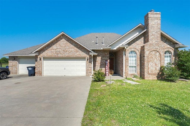 1811 N Bryan St, Shawnee, OK 74804 - view of front of home featuring brick siding, an attached garage, a chimney, and driveway