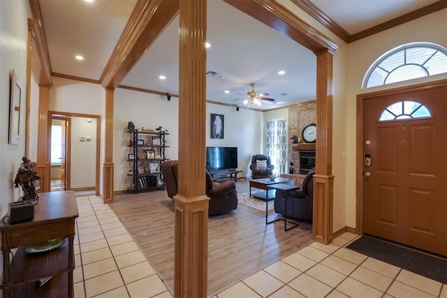 1811 N Bryan St, Shawnee, OK 74804 - foyer featuring decorative columns, crown molding, plenty of natural light, a brick fireplace, and ceiling fan