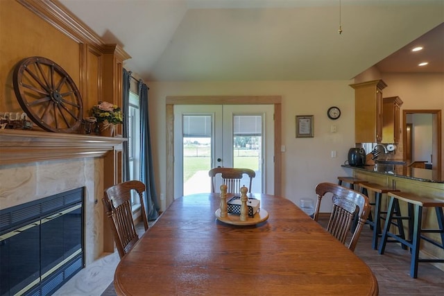 1811 N Bryan St, Shawnee, OK 74804 - dining room featuring french doors, recessed lighting, vaulted ceiling, a premium fireplace, and wood finished floors