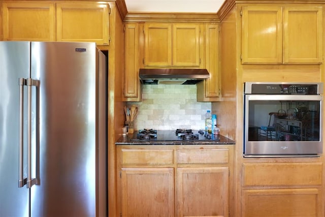 1811 N Bryan St, Shawnee, OK 74804 - kitchen featuring stainless steel appliances, under cabinet range hood, decorative backsplash, and dark stone countertops
