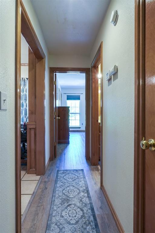 1811 N Bryan St, Shawnee, OK 74804 - hall featuring light wood-type flooring, a textured wall, and baseboards