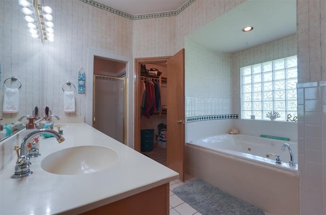1811 N Bryan St, Shawnee, OK 74804 - bathroom featuring double vanity, wallpapered walls, a bath, tile patterned floors, and a walk in closet