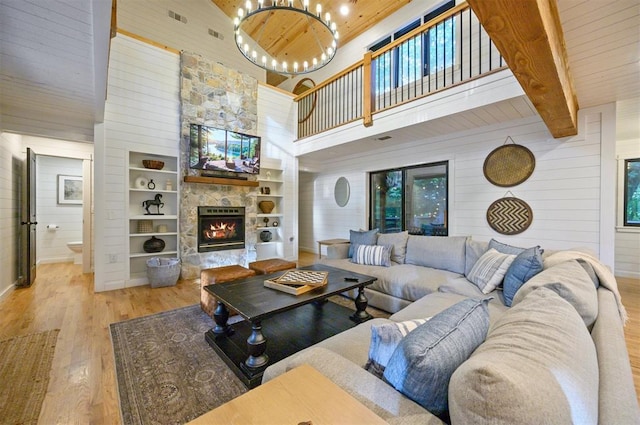 47 White Pine Rd, Broken Bow, OK 74728 - living area with wood finished floors, a towering ceiling, wood walls, a fireplace, and a chandelier