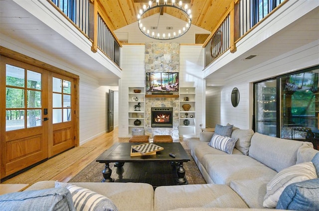 47 White Pine Rd, Broken Bow, OK 74728 - living room featuring high vaulted ceiling, wood finished floors, a stone fireplace, wood ceiling, and a chandelier