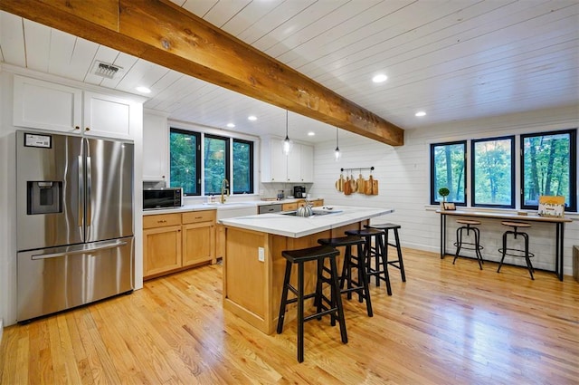 47 White Pine Rd, Broken Bow, OK 74728 - kitchen featuring stainless steel refrigerator with ice dispenser, black microwave, light wood-style floors, light countertops, and a kitchen breakfast bar