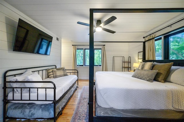 47 White Pine Rd, Broken Bow, OK 74728 - bedroom with wood finished floors, multiple windows, wood walls, and ceiling fan