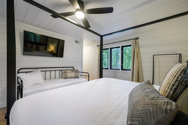 47 White Pine Rd, Broken Bow, OK 74728 - bedroom with wooden walls, wood finished floors, and a ceiling fan