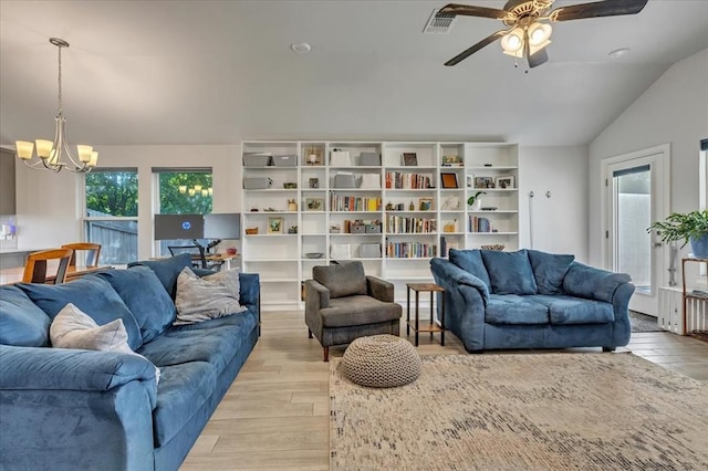 12905 NW 4th St, Yukon, OK 73099 - living area with a chandelier, light wood-style floors, vaulted ceiling, and plenty of natural light