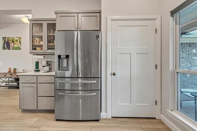 12905 NW 4th St, Yukon, OK 73099 - kitchen featuring stainless steel fridge, gray cabinets, light wood-style flooring, and glass insert cabinets