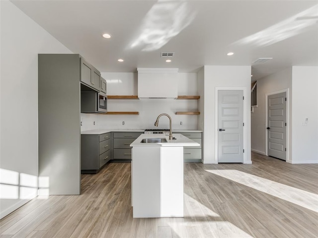 2812 Shoreridge Ave Unit 2814, Norman, OK 73072 - kitchen with open shelves, gray cabinetry, a sink, an island with sink, and light wood finished floors