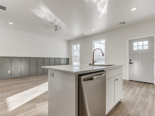 2812 Shoreridge Ave Unit 2814, Norman, OK 73072 - kitchen with stainless steel dishwasher, a sink, a center island with sink, a ceiling fan, and light wood-style floors