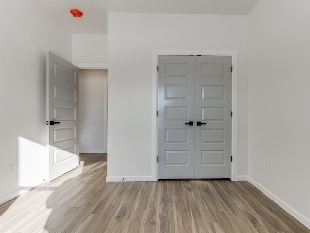 2812 Shoreridge Ave Unit 2814, Norman, OK 73072 - unfurnished bedroom with light wood-type flooring, baseboards, and a closet