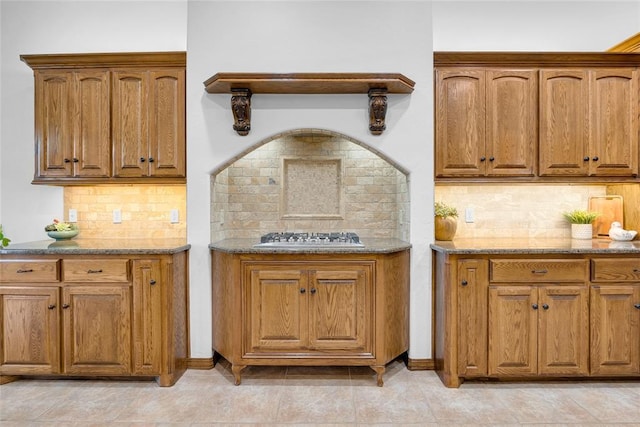 1116 River Birch Dr, Yukon, OK 73099 - kitchen with stainless steel gas cooktop, brown cabinets, and decorative backsplash