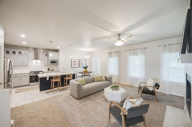 18020 Mounts Farm Rd, Edmond, OK 73012 - living area with light carpet, a ceiling fan, a fireplace with flush hearth, light tile patterned flooring, and recessed lighting