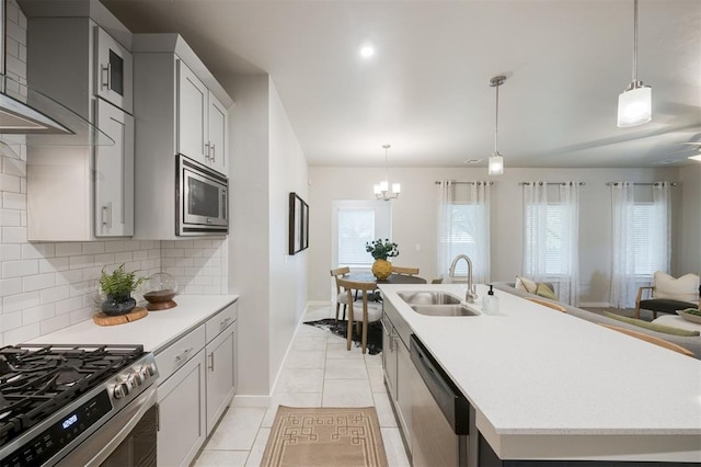 18020 Mounts Farm Rd, Edmond, OK 73012 - kitchen with appliances with stainless steel finishes, a sink, baseboards, decorative backsplash, and an island with sink