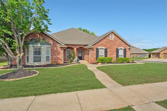 4605 NW 161st St, Edmond, OK 73013 - view of front facade featuring brick siding, a front yard, and roof with shingles
