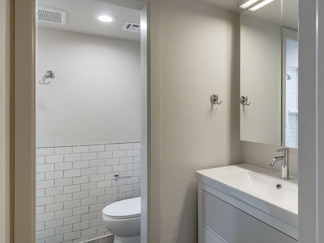 1110 Sherwood Ln Unit 223, Nichols Hills, OK 73116 - bathroom featuring vanity, recessed lighting, and tile walls
