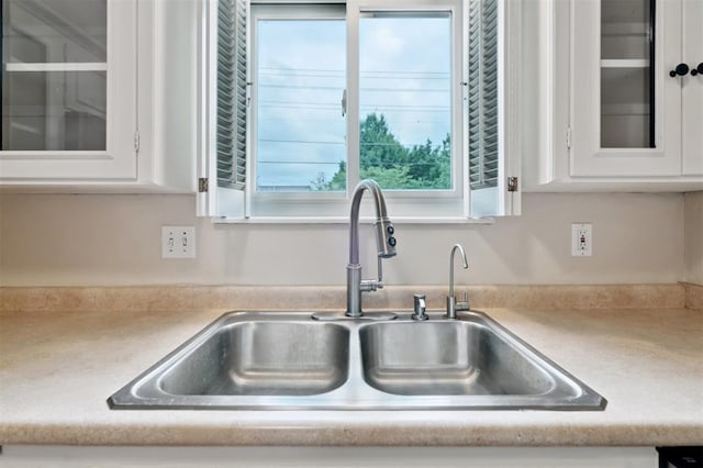 3119 W Wilshire Blvd, Oklahoma City, OK 73116 - kitchen view of a sink, white cabinets, glass insert cabinets, and light countertops