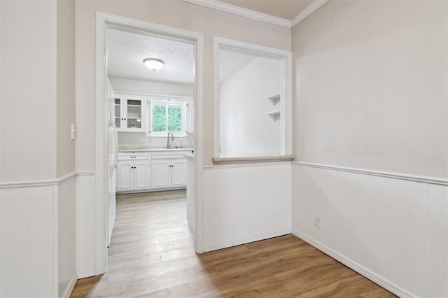3119 W Wilshire Blvd, Oklahoma City, OK 73116 - corridor featuring a sink, crown molding, light wood finished floors, and wainscoting