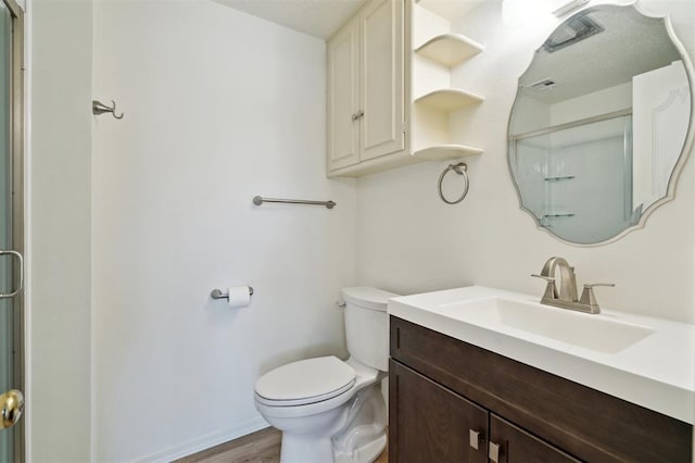 3119 W Wilshire Blvd, Oklahoma City, OK 73116 - full bathroom with vanity, toilet, a shower with shower door, and wood finished floors