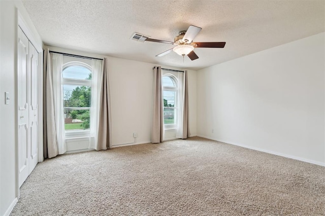 3119 W Wilshire Blvd, Oklahoma City, OK 73116 - carpeted spare room with plenty of natural light, a textured ceiling, ceiling fan, and baseboards